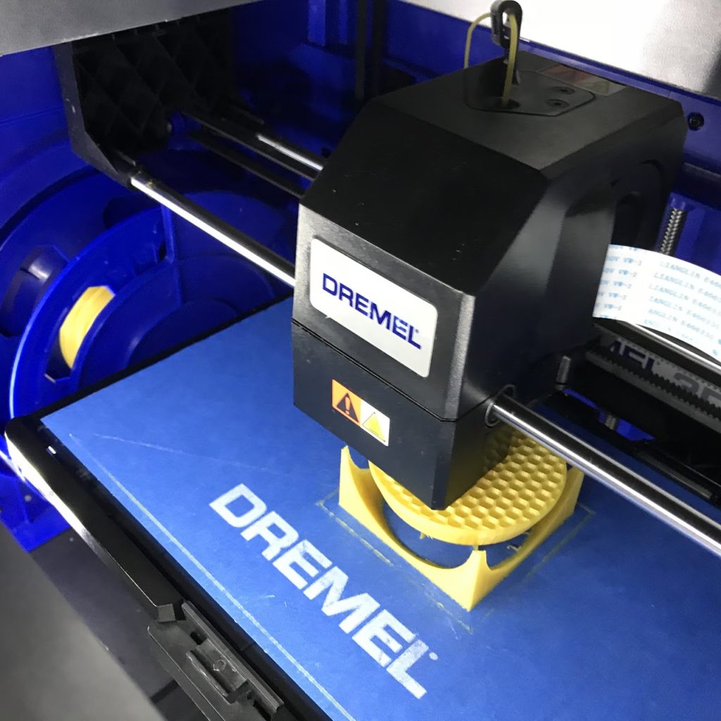 Dremel 3D Printer printing a yellow ball in a box.