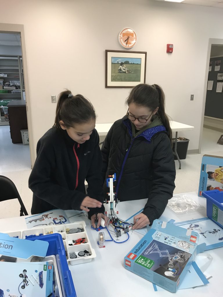 Two girls working with Lego engineering kit to create a build in 4-H Engineering class