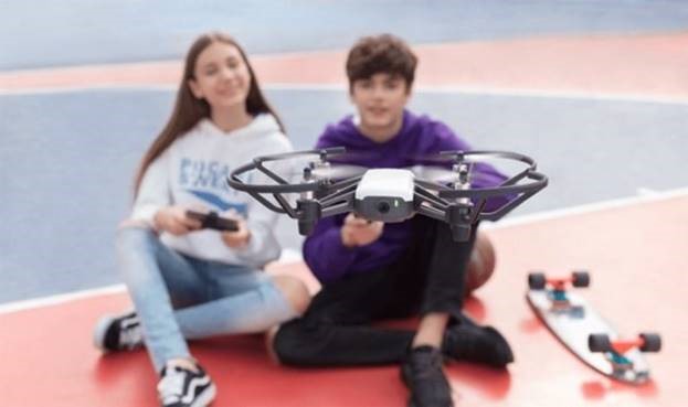 teen girl and boy flying a drone