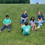 youth sitting in a field wearing 4-H shirts