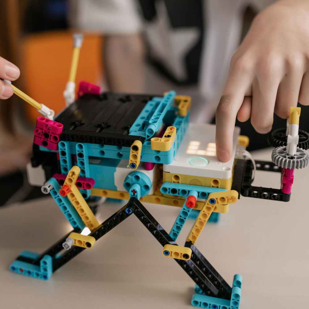 A child works on a LEGO bridge