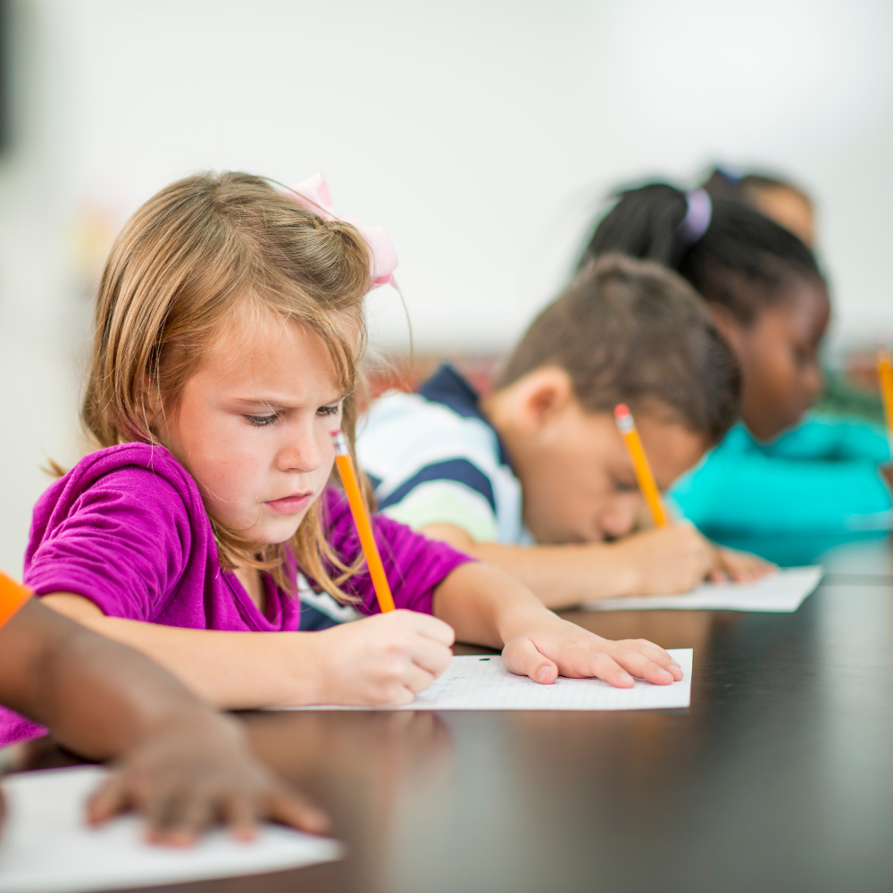 A young girl looking determined as she writes