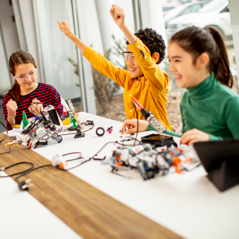 kids cheering as they complete a lego robotics build