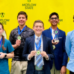 group of students stand with their awards from project achievement day
